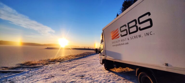 Specialty Bolt & Screw delivery truck in Finland with scenic sunset backdrop.