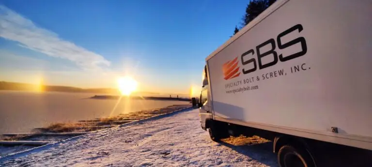 Specialty Bolt & Screw delivery truck in Finland with scenic sunset backdrop.